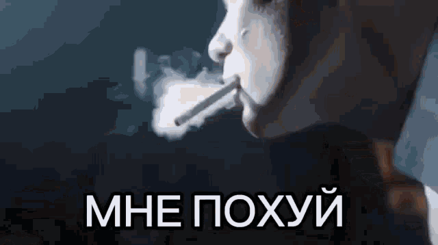 a man is smoking a cigarette with smoke coming out of his mouth in russian .