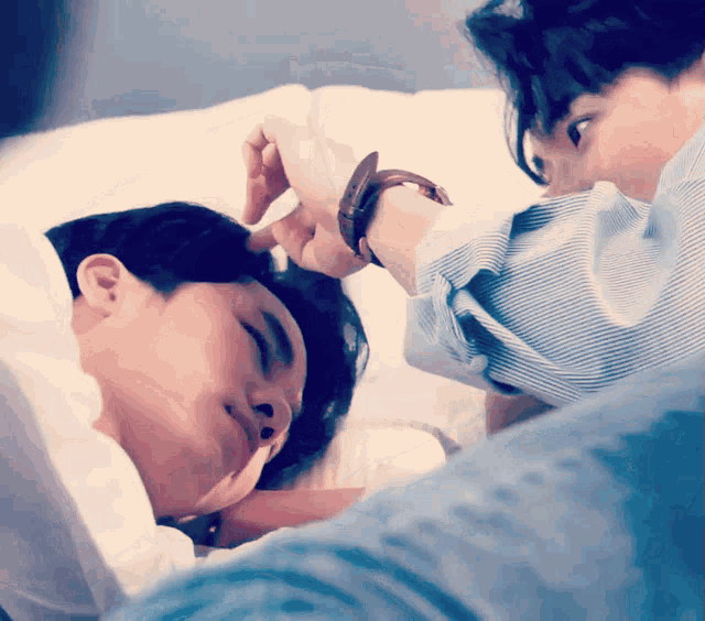 a man with a watch on his wrist is putting his hand on another man 's head