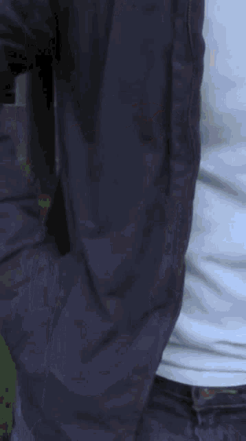 a close up of a person 's torso in a white shirt and blue jeans