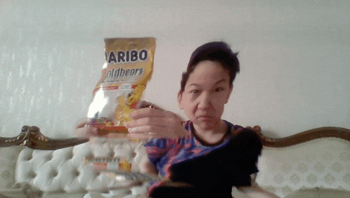 a young boy holding a bag of haribo goldbears