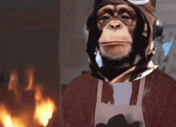 a monkey wearing a helmet and apron is standing in front of a fire .