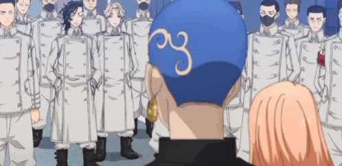 a group of people are standing in a line and one of them has the letter g on his head