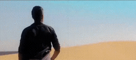 a man standing in a desert with the words t'es ou ? above him