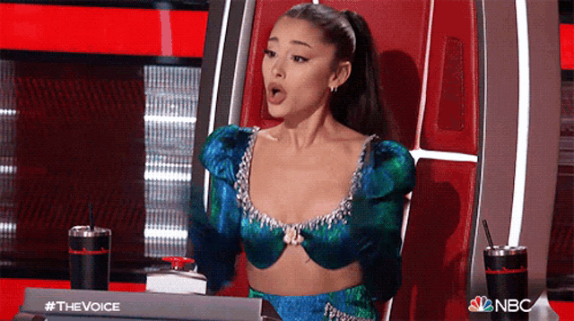 ariana grande is sitting in a chair on the voice