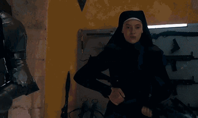 two nuns are standing next to each other in a room with guns on the walls
