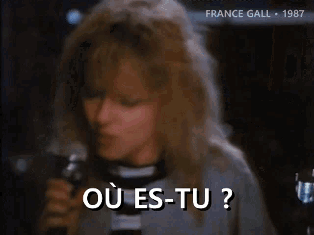 a woman singing into a microphone with the words où es-tu written in white