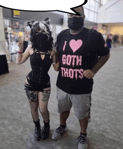 a man wearing a shirt that says i love goth thots stands next to a woman