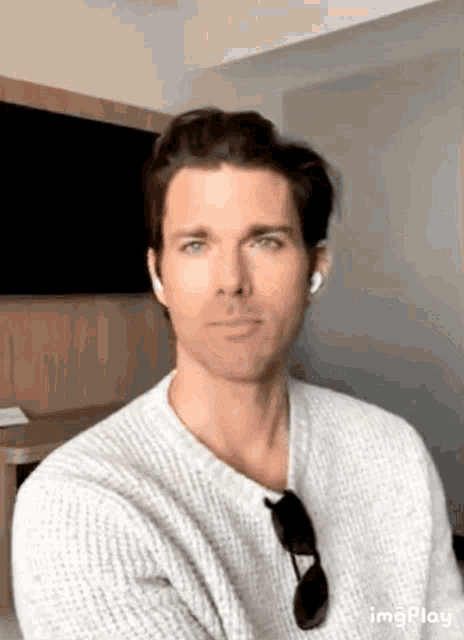 a man wearing headphones and sunglasses is sitting in a room .