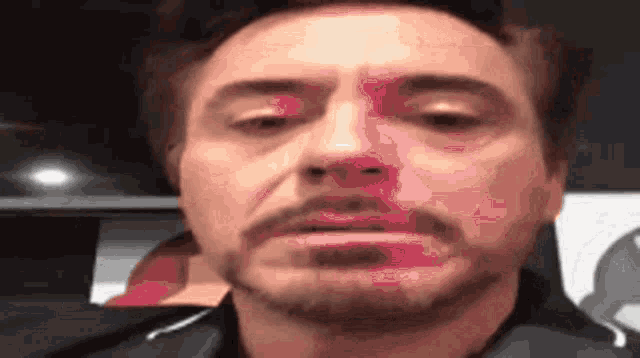 a close up of a man with a beard making a face .
