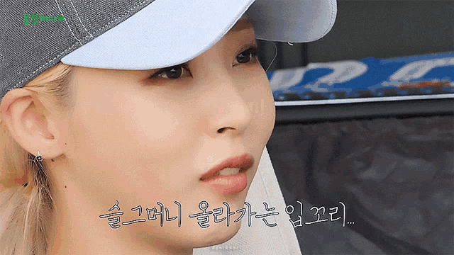 a close up of a woman wearing a baseball cap with foreign writing