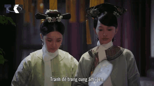 two women are standing next to each other with a caption that says tránh de trong cung ám i len