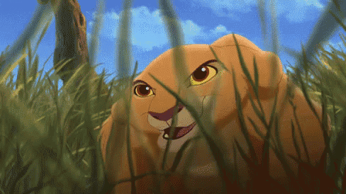 a cartoon lion is standing in the grass and looking up