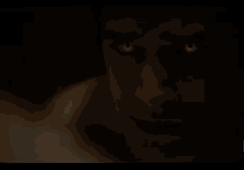 a man without a shirt is standing in a dark room .