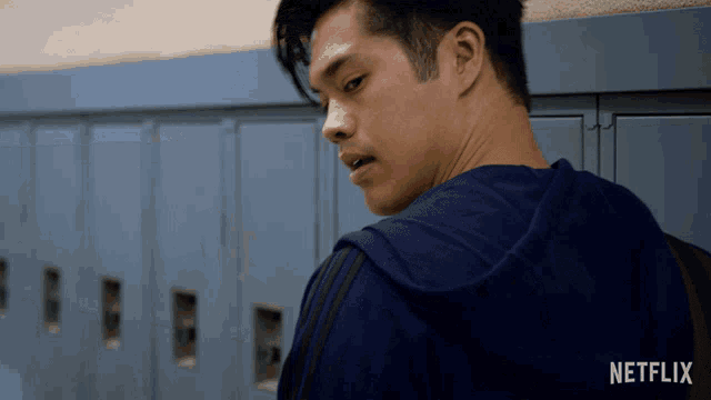 a man in a blue hoodie with a netflix logo on the back of his shirt
