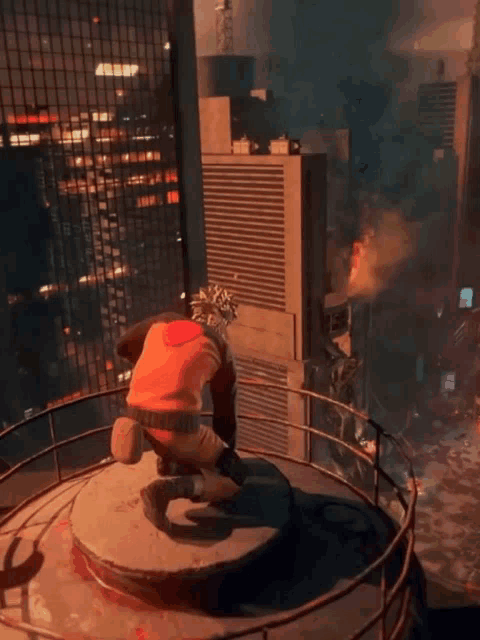 a man is kneeling on top of a circular platform in front of a city