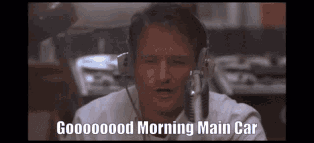a man wearing headphones and a microphone says good morning main car