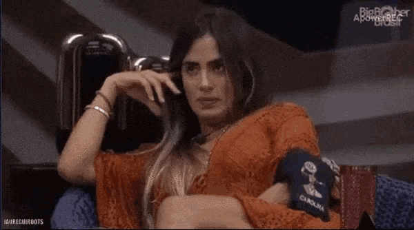 a woman is sitting in a chair with her hand on her chin and the words big brother above her head