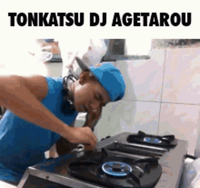 a man in a blue hat is cooking on a gas stove while talking on a cell phone .