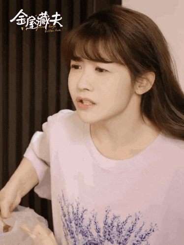 a woman wearing a purple shirt with flowers on it is making a funny face