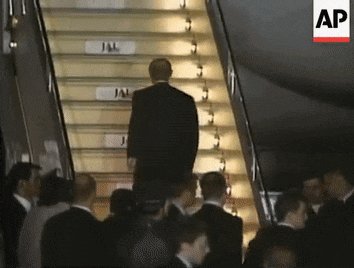 a man in a suit is walking up a set of stairs with a sign that says jal on it