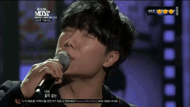 a man singing into a microphone with the word must on the bottom left