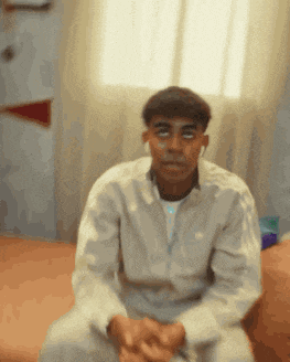 a man in a white shirt is sitting on a couch