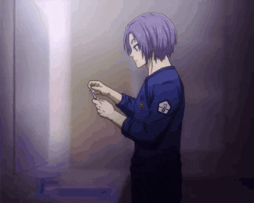 a man with purple hair is standing in a dark room holding something in his hand