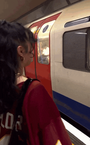 a woman wearing a red shirt with the number 03 on the back