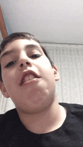 a young boy making a funny face with his tongue out