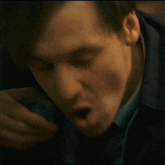 a blurry picture of a man covering his mouth with his hands