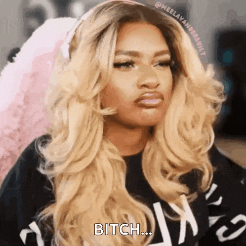 a woman with long blonde hair and a black shirt is making a funny face and saying bitch .