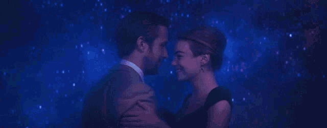 a man and a woman are dancing in front of a starry night sky