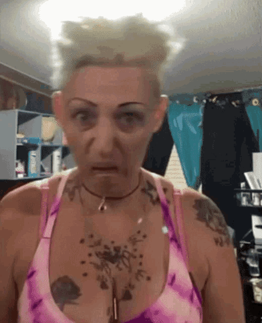 a woman with a tattoo on her chest is making a funny face