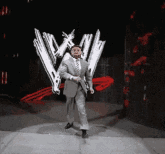 a man in a suit and tie is dancing in front of a large w logo