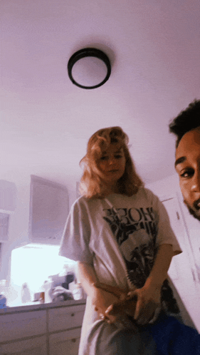 a man and a woman are posing for a picture and the woman is wearing a shirt that says ' bon ' on it