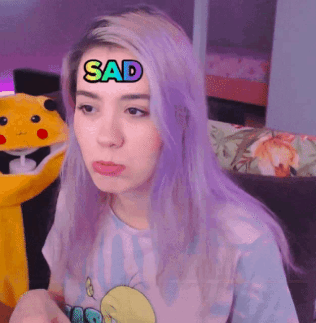 a girl with purple hair has a sad sticker on her forehead