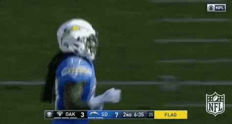 a football player in a blue jersey is standing on a field .
