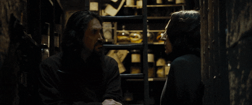 harry potter is standing in a dark room with a picture on the wall