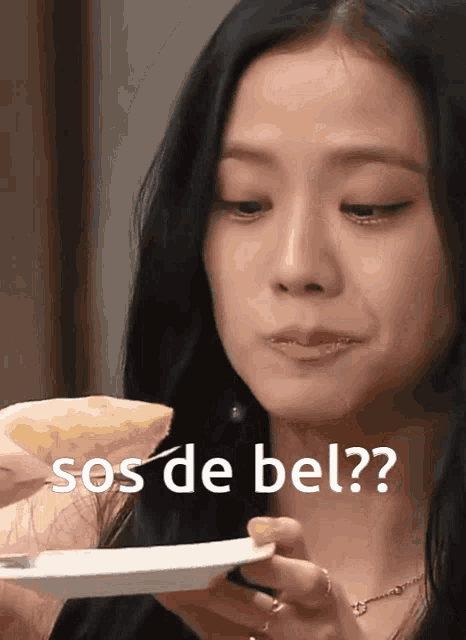 a woman eating a slice of pizza with the words sos de bel written below her