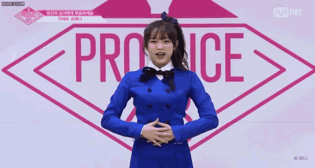 a girl in a blue suit is standing in front of a sign that says produce