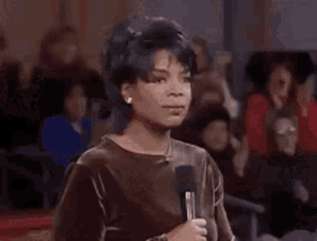 a woman is standing in a room with her arms in the air .