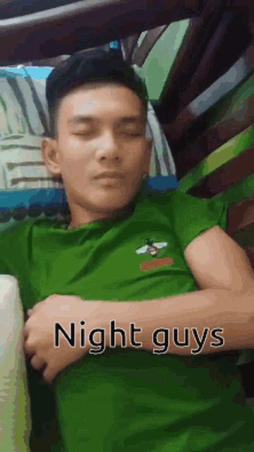 a man in a green shirt is sleeping in a bunk bed with the caption night guys .