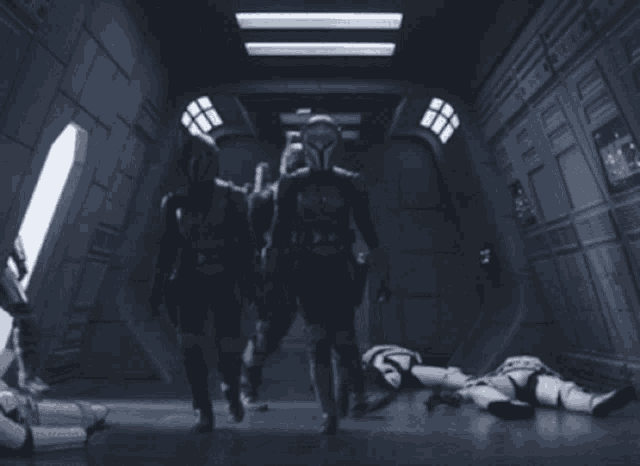 a group of soldiers standing in a dark room with a few robots laying on the floor