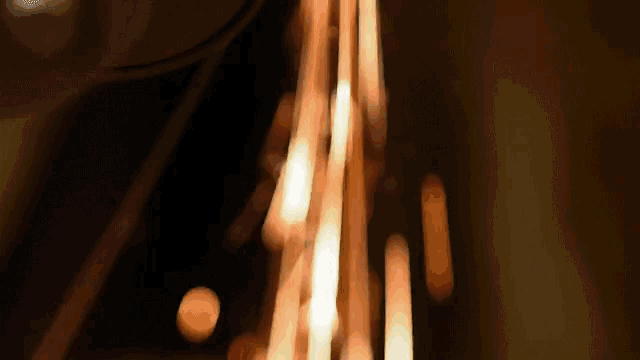 a blurred image of a candle being lit up in the dark