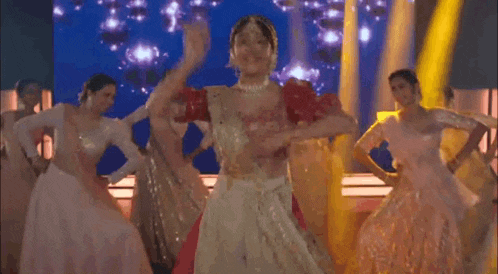 a group of women are dancing on a stage in front of a crowd .