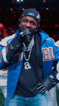 a man singing into a microphone wearing a jacket with the letter a on it