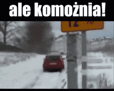 a red car is driving down a snowy road in front of a yellow sign that says 12 70
