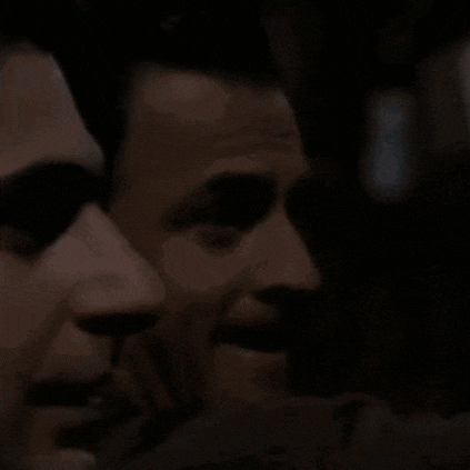 a close up of two men 's faces in a dark room