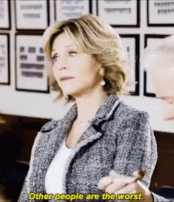 a woman is smoking a cigarette while talking to a man and says other people are the worst .