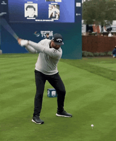 a man swinging a golf club on a golf course with a sign behind him that says tcjr